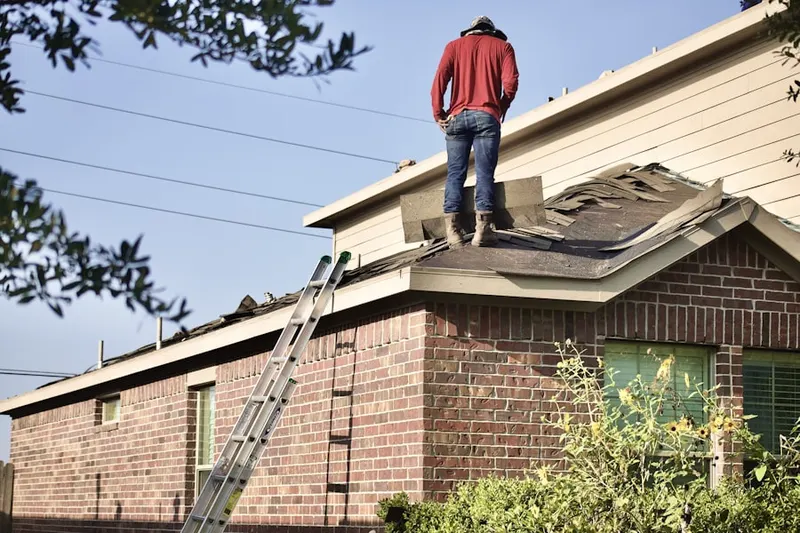 Professional roofer working on a residential roof in East Milford